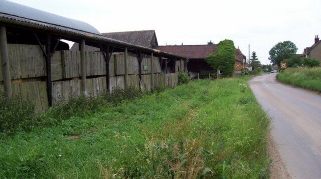 Ballslough Farm and Kimpton. The buildings of Ballslough Farm (left, foreground) are at the western edge of this grid square before the road runs past the speed limit signs into Kimpton in TL1718.