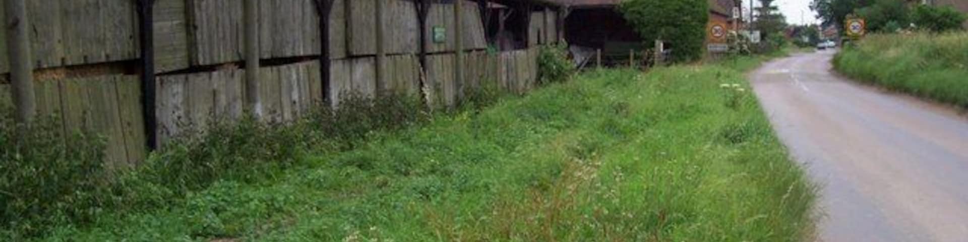 Ballslough Farm and Kimpton. The buildings of Ballslough Farm (left, foreground) are at the western edge of this grid square before the road runs past the speed limit signs into Kimpton in TL1718.