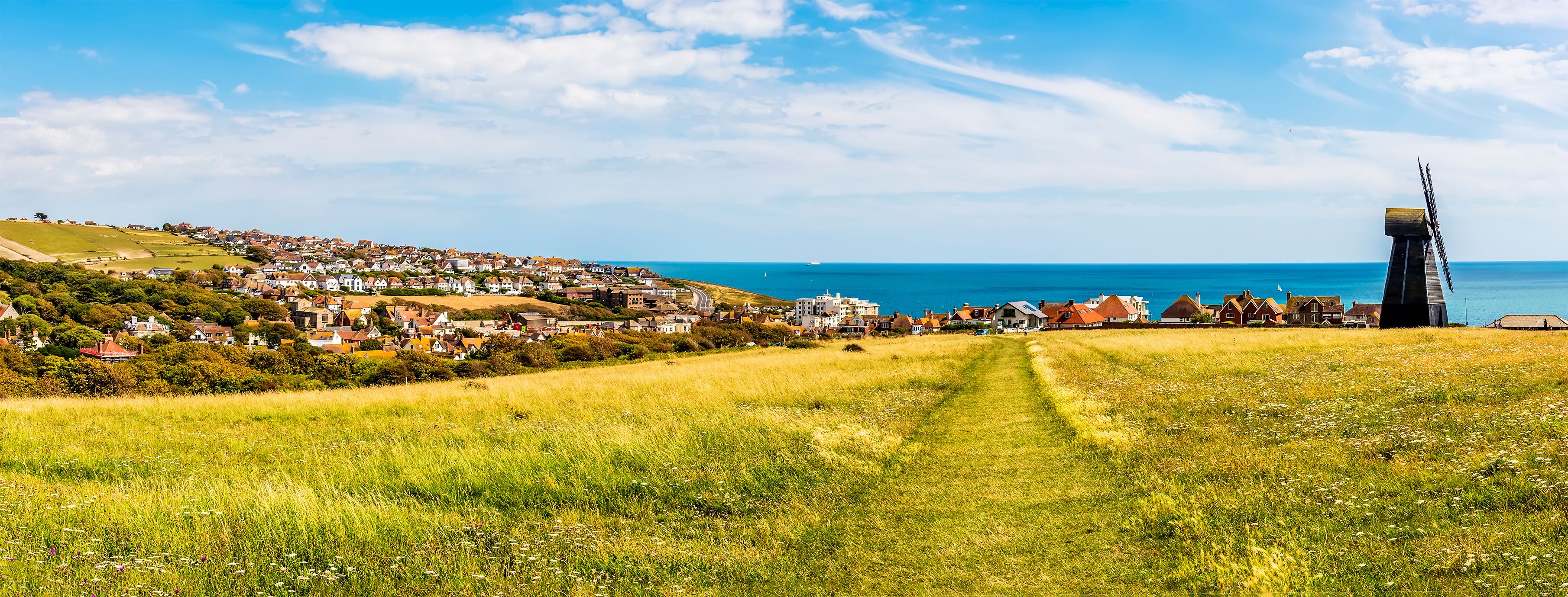 A panorama down Beacon Hill towards the town of Rottingdean, Sussex, UK in summer
