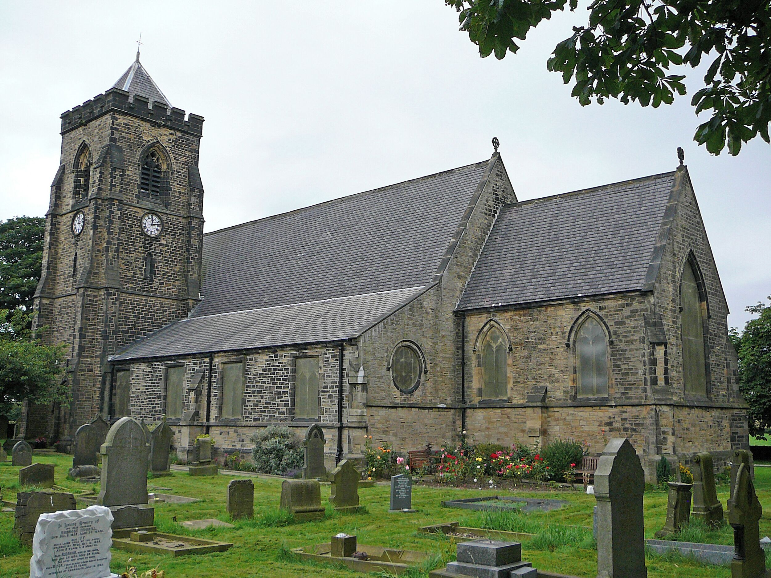 A historic church with a tall tower and a cemetery in front.