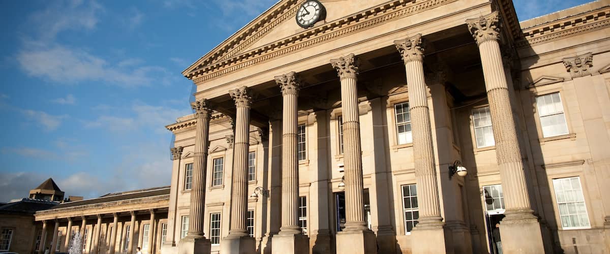 A classical building with large columns and a clock on the facade.