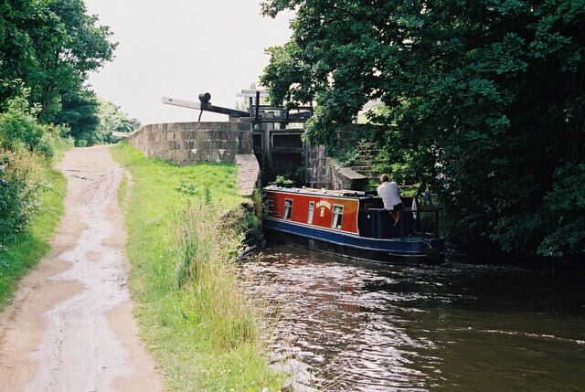 Holme Lock No 19E, Huddersfield Narrow Canal A westbound cruiser nudges open the gates of Holme Lock, a practice not to be recommended as it leads to increased wear and tear on lock gates.