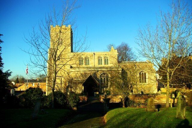 A historic stone church with a prominent tower and arched entrance.