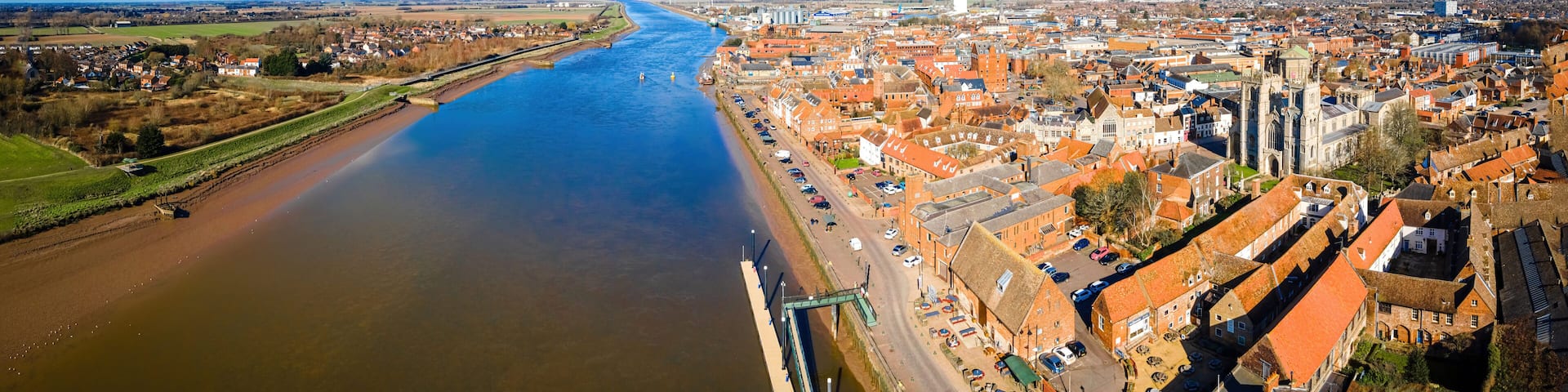 A river flowing through a town with historic buildings and a bridge.