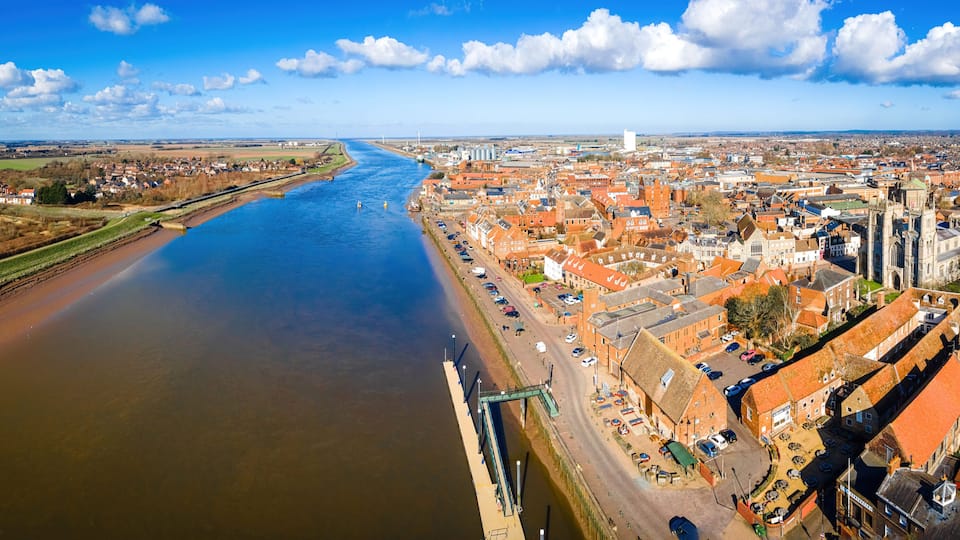 A river flowing through a town with historic buildings and a bridge.