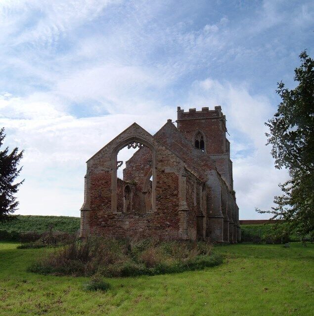 An old stone church with a bell tower and arched windows.