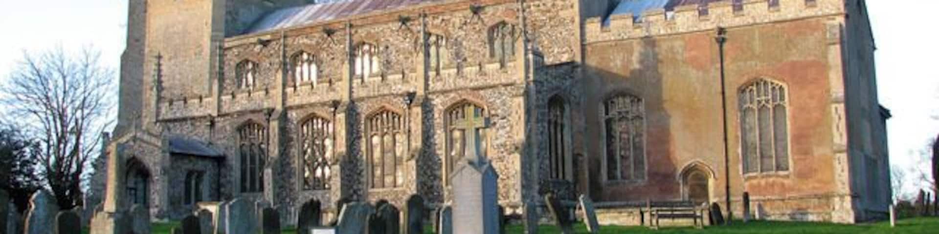 St Martin's church illuminated by winter sunlight. The war memorial can be seen in the foreground. St Martin > 1636596 is one of formerly two churches in the village of Fincham. St Michael's church (abandoned in 1745 after the collapse of its tower) used to be situated about 200 metres to the west and after it was pulled down some of it was used to repair St Martin. The church sits on an elevation north of High Street, the main thoroughfare through the village. The building dates mainly from the 15th century but was restored in the mid to late 1800s when the south porch was added. The stained glass windows > 1636627 date from that time also. The vestry on the north side dates from around 1503 and has an extra room above for the use of an assistant priest. The rood screen with its elaborately carved tracery and original painted decoration on the panels > 1636640 is C15. The most notable feature of the church is the magnificent Norman font > 1636645 which came from St Michael's church. It is only one of 13 square Norman fonts that still survive in north-west Norfolk and one of only three which have figures carved on the sides of the bowl. Six boards dating from 1717 and inscribed with texts from the Bible > 1636606 hang on the nave walls. The pulpit and pews were installed in Victorian times.