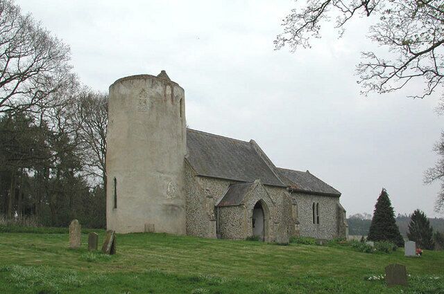 A church with a tower and a stone building.