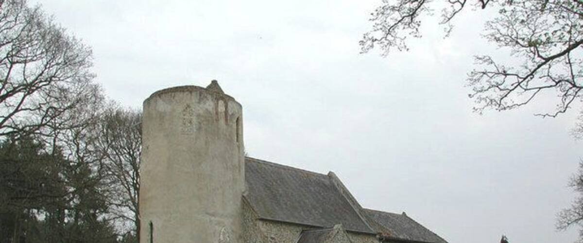 A church with a tower and a stone building.