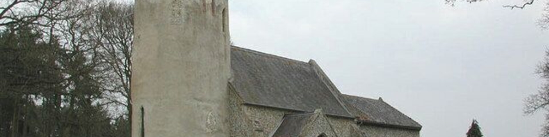 A church with a tower and a stone building.