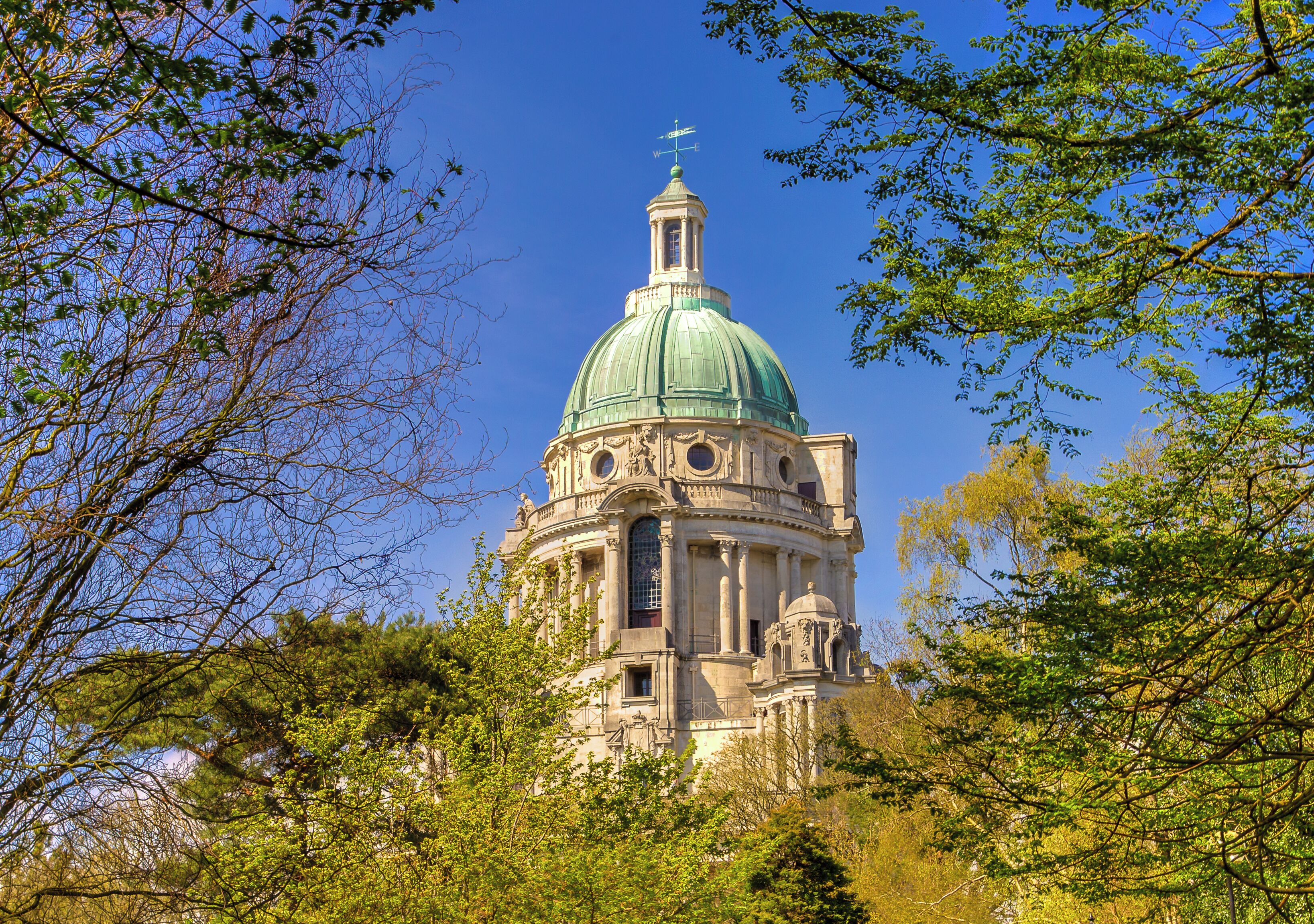 A historic building with a green dome and intricate architecture.
