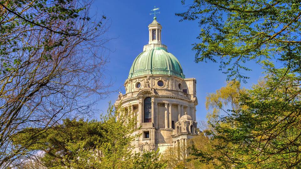 A historic building with a green dome and intricate architecture.