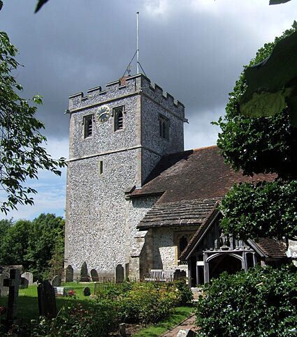 A stone tower with a clock, a church with a steeple, and a well-maintained garden.