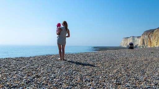 Woman holding a baby at Newhaven beach, East Sussex, England