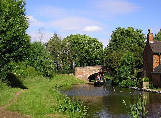 Coventry Canal at Fradley Bridge, Staffordshire. The Coventry Canal was started in 1768, and reached Atherstone by 1771, but lack of money meant that although it was planned to end at Fradley Junction, it had still only reached Fazeley by 1790. In the meantime, the Birmingham and Fazeley Canal had been built and used the Coventry Canal's original planned line to Whittington Brook. The Grand Trunk Canal Company then continued northwards to Fradley Junction. This final section was bought back by the Coventry Company later and they placed numbers on their bridges. It explains how a long section of the canal including that pictured here is detached from the rest of the Coventry canal. The five and a half miles of canal running through Hopwas remains as part of the Birmingham and Fazeley Canal, which has un-numbered bridges. Coventry Canal Bridge No 77 at Fazeley Junction is five and a half miles from bridge No 78 at Whittington Brook. Fradley bridge is No 90.