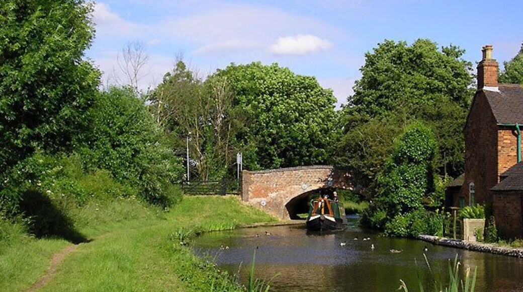 Coventry Canal at Fradley Bridge, Staffordshire. The Coventry Canal was started in 1768, and reached Atherstone by 1771, but lack of money meant that although it was planned to end at Fradley Junction, it had still only reached Fazeley by 1790. In the meantime, the Birmingham and Fazeley Canal had been built and used the Coventry Canal's original planned line to Whittington Brook. The Grand Trunk Canal Company then continued northwards to Fradley Junction. This final section was bought back by the Coventry Company later and they placed numbers on their bridges. It explains how a long section of the canal including that pictured here is detached from the rest of the Coventry canal. The five and a half miles of canal running through Hopwas remains as part of the Birmingham and Fazeley Canal, which has un-numbered bridges. Coventry Canal Bridge No 77 at Fazeley Junction is five and a half miles from bridge No 78 at Whittington Brook. Fradley bridge is No 90.