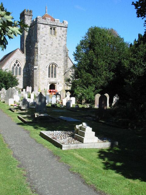 A church with a tall tower and a cemetery with gravestones.