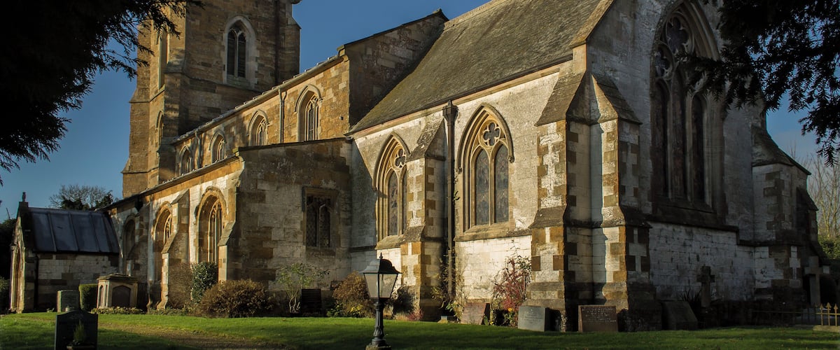 The church dates from the 13th century onwards. The nave was rebuilt in 1843, and the chancel in 1873 by Fowler. The church is built from ironstone with limestone dressings, with a slate and lead roof. There is a western tower with three bells, nave with clerestory, north and south aisles, chancel and south porch. The church originally consisted of tower, nave, chancel and south aisle only, and there is no record of any restoration before 1831. The four bay south arcade is early 13th century with circular piers. The north arcade is all 19th century. The nave roof is 19th century, but incorporates 15th C. carved wooden figures to the hammer beams. The ceiling has been elaborately decorated with roundels containing paintings of Saints. The words of the Te Deum are written around the walls of the chancel at the border with the roof, and the theme of the decoration relates to the first verse of the Te Deum. There is a fine sculptured stone reredos, painted and gilded. The organ is also painted and gilded by J.G. Smyth. All fittings are 19th century apart from the 15th century octagonal font. The 2 manual organ is by Nicholson of Worcester from 1904. Photo by J.Hannan-Briggs
