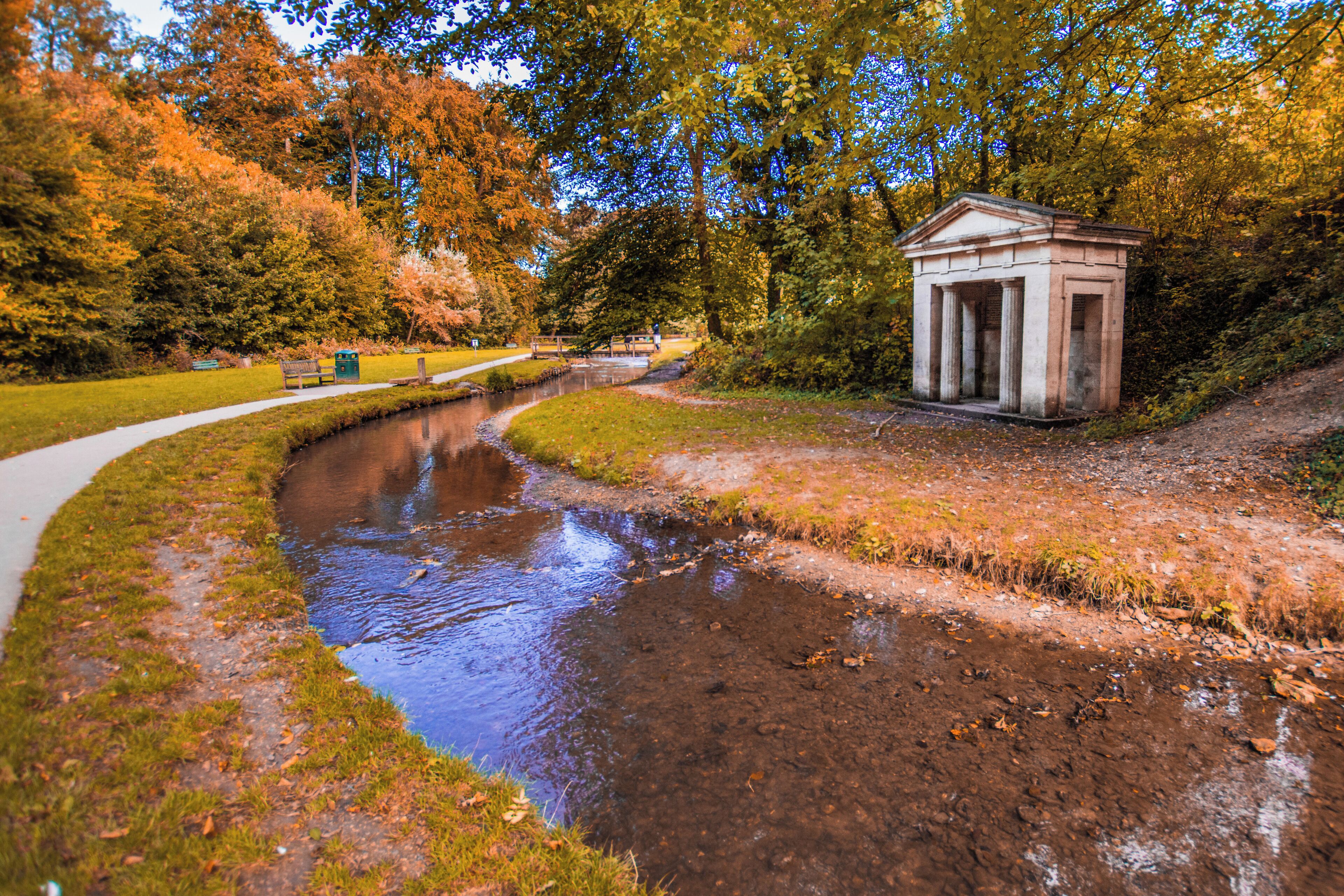 A river, a small temple, and autumn trees.