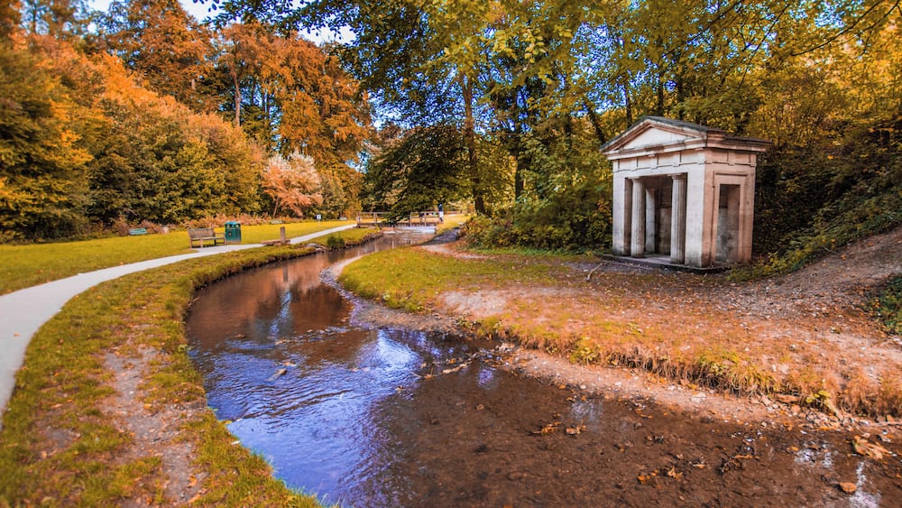 A river, a small temple, and autumn trees.