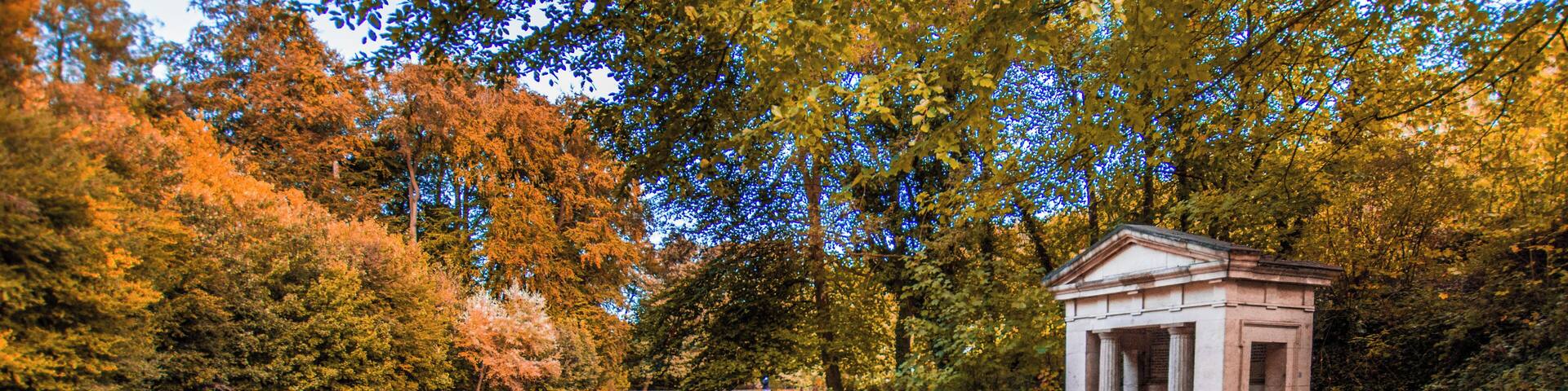 A river, a small temple, and autumn trees.