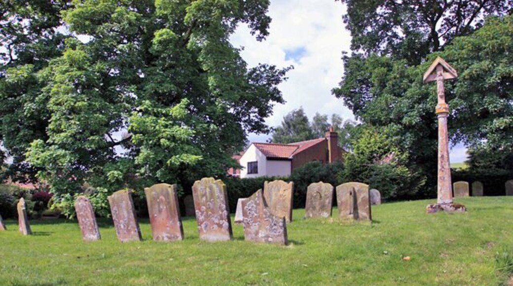The Churchyard, St Philips, Brinkhill This photograph looks across the lichen encrusted gravestones to a private residence.