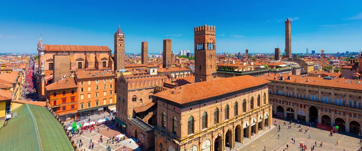 A historic city square with prominent towers, a cathedral, and a large dome.