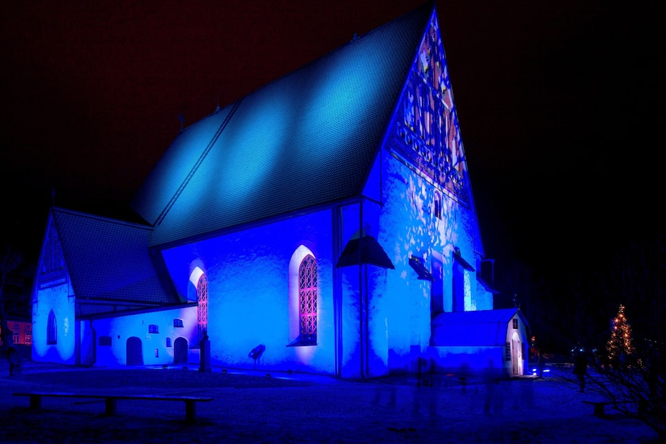 A church illuminated with blue lights at night.