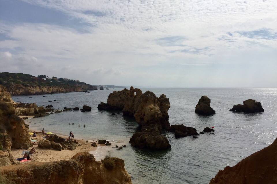 A coastal landscape with rocky formations and a beach.
