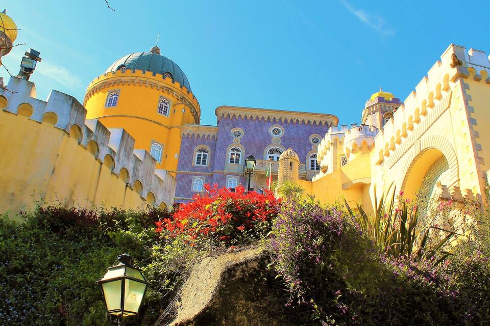 A historic building with yellow walls, a dome, and a tower.