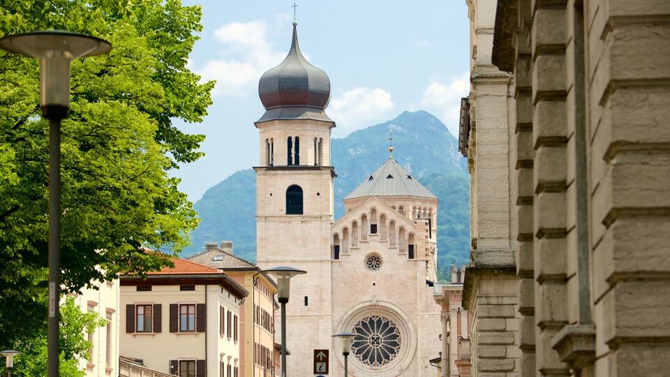 A church with a large dome and a bell tower, surrounded by trees and buildings.
