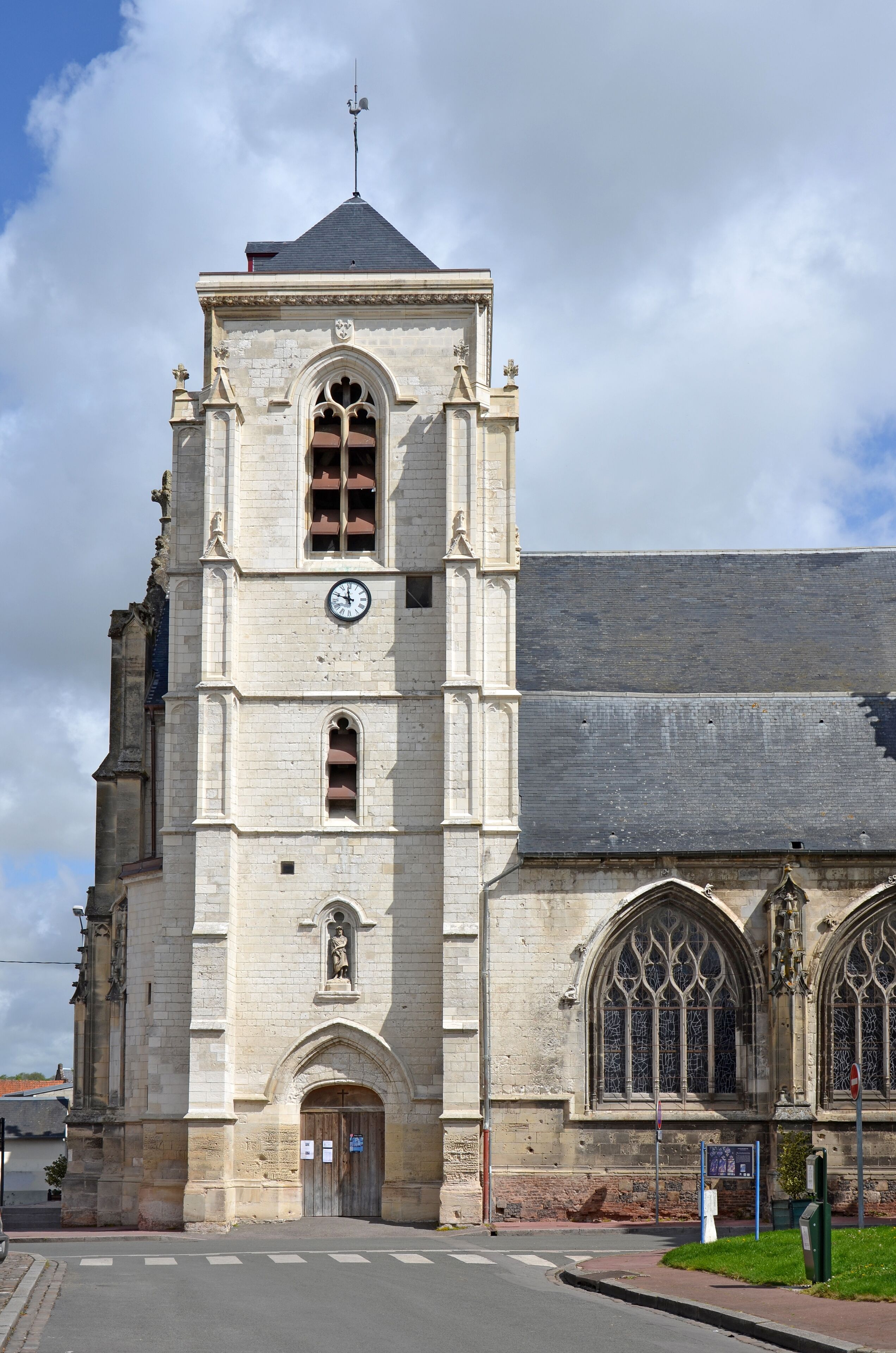A historic church with a tall bell tower, arched windows, and a weather vane.