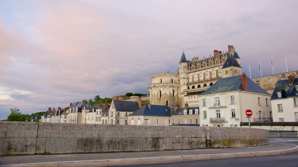 A historic castle with multiple towers and a stone wall in the foreground.