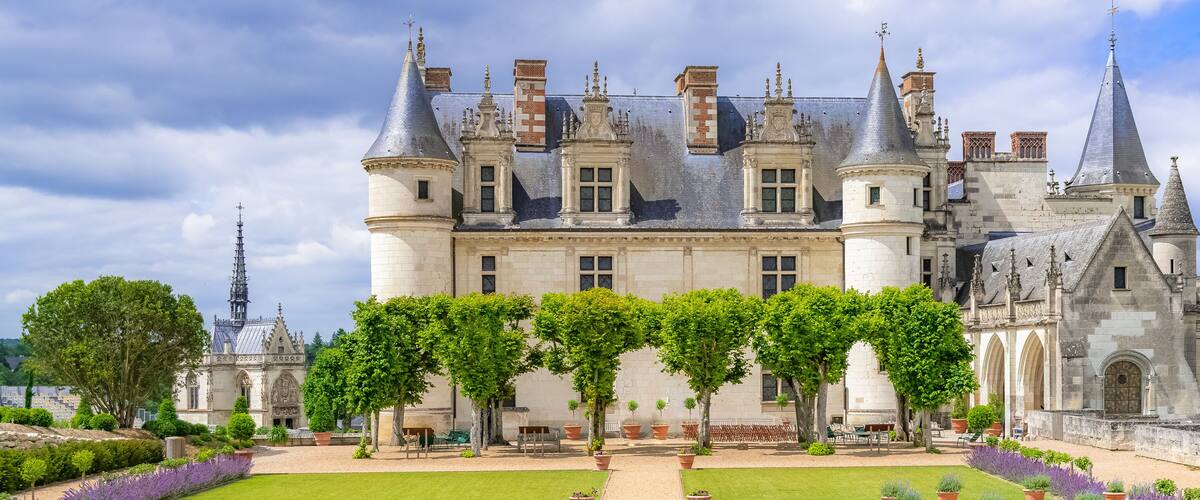 Un château historique, doté de tourelles, d’une cour intérieure et bordé par une rivière.