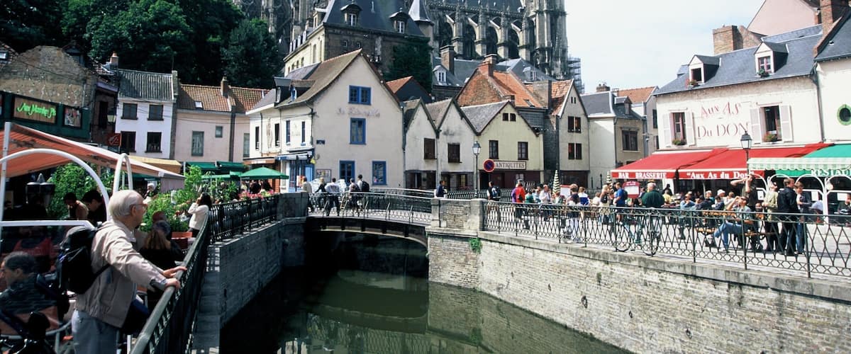 A historic town with a prominent cathedral, narrow streets, and a canal.
