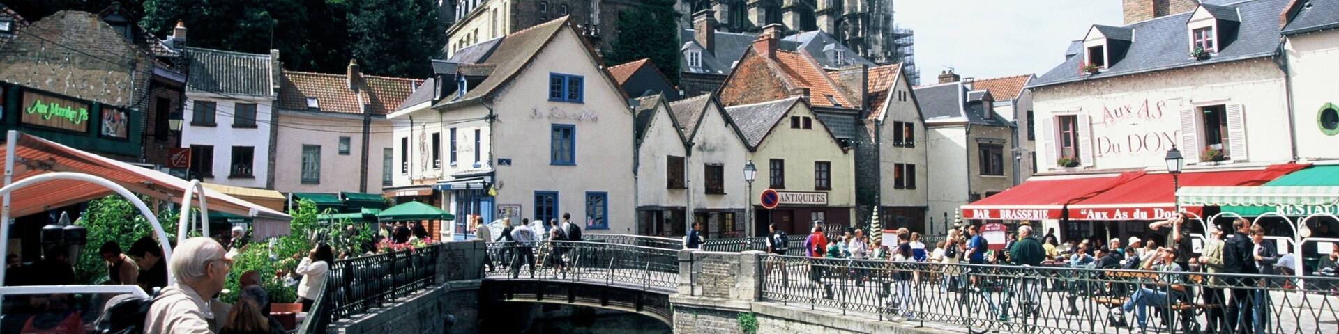 A historic town with a prominent cathedral, narrow streets, and a canal.
