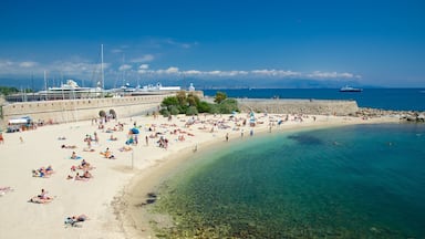 Antibes caracterizando uma praia de areia assim como um grande grupo de pessoas