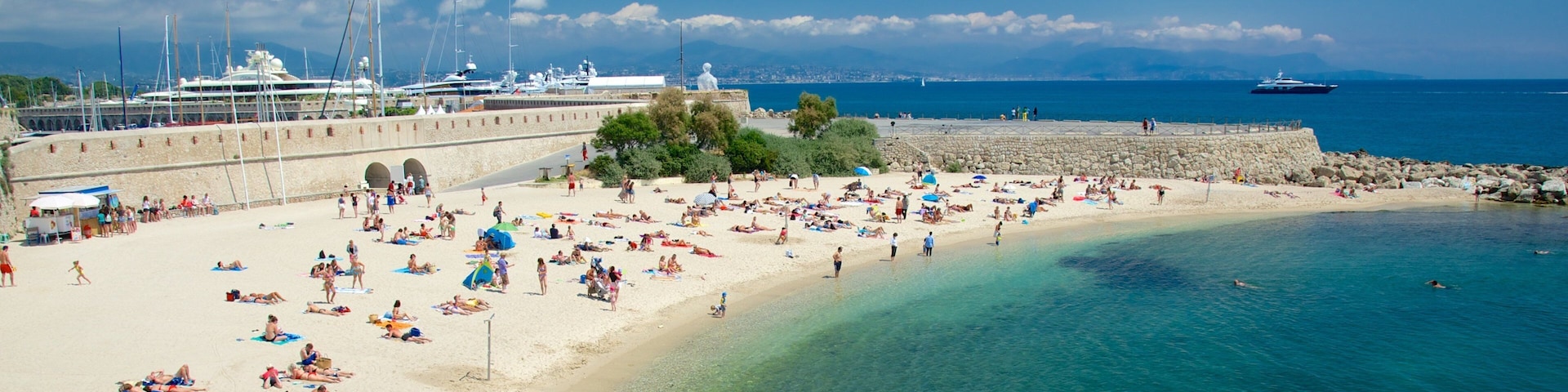 Antibes which includes a beach as well as a large group of people