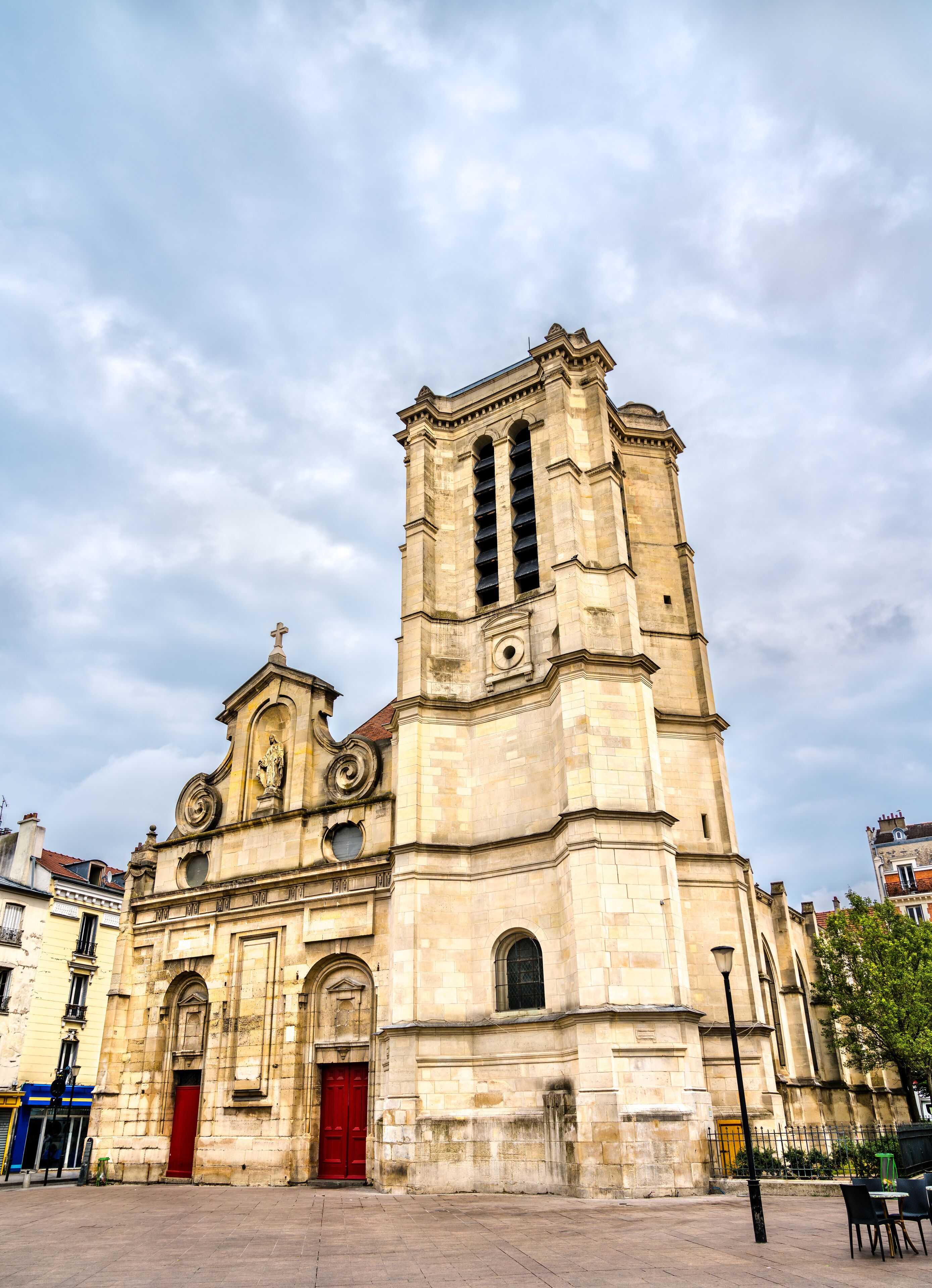 A historic church with a tall bell tower and red doors.