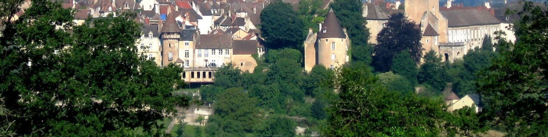 A cathedral with a tall spire, surrounded by historic buildings and trees.