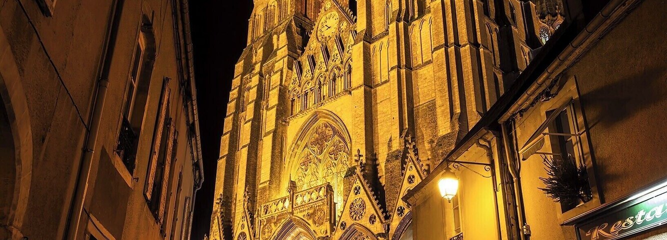 Una catedral gótica con arquitectura elaborada y una puerta roja en su entrada.