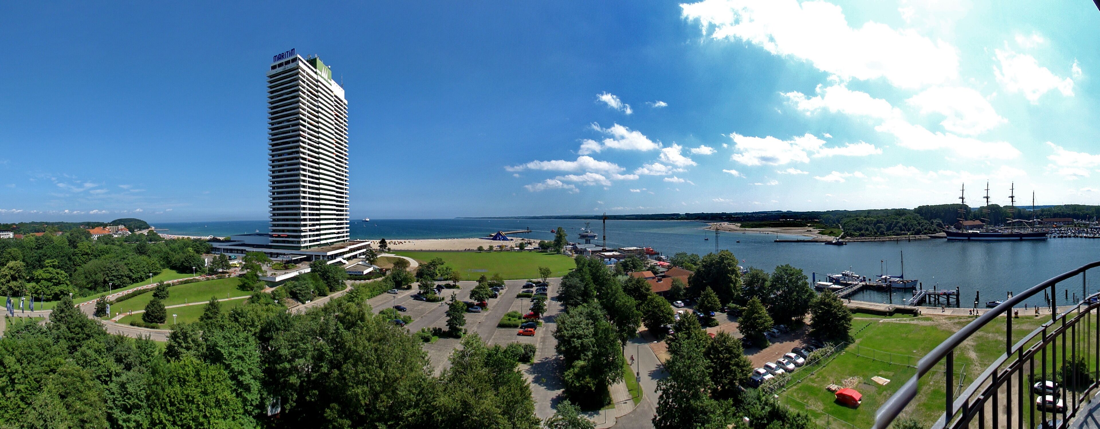 Un immeuble de grande hauteur, une marina et une étendue d’eau.