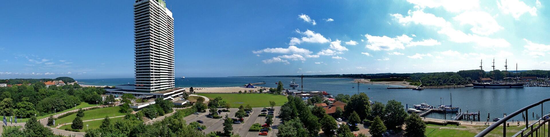 A tall building, a marina, and a body of water.