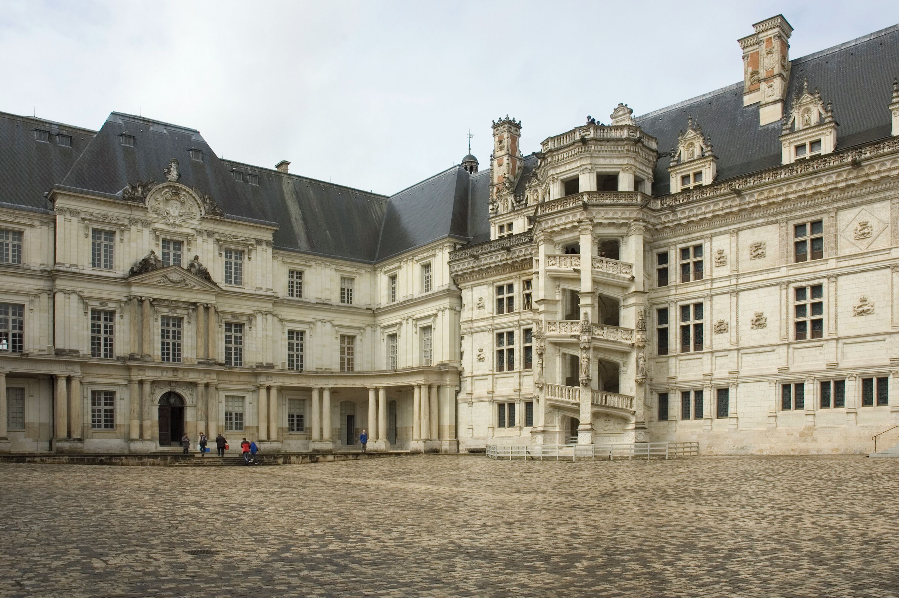 A historic building with ornate architecture and a cobblestone courtyard.