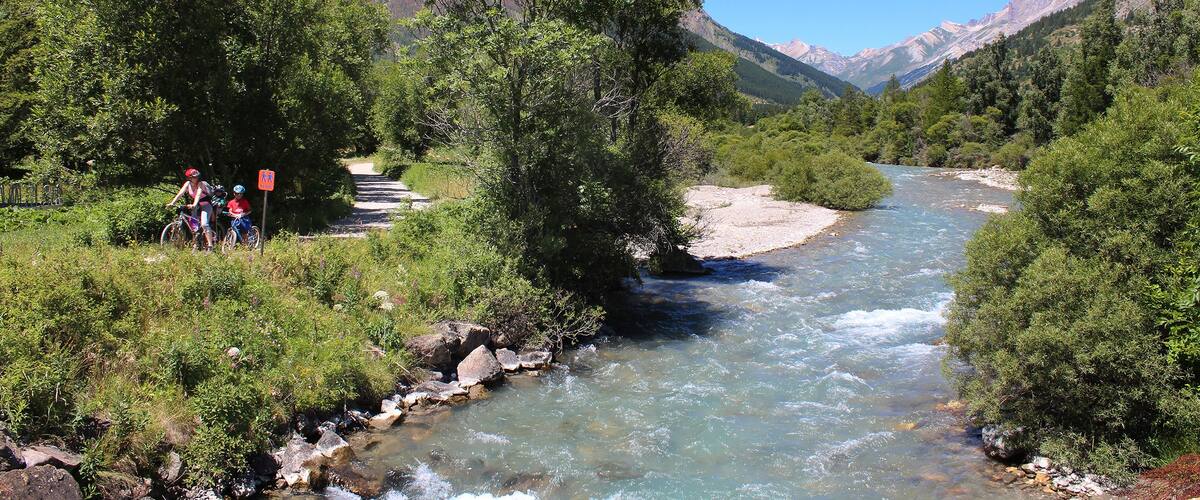 A river flowing through a mountainous landscape with lush greenery and rocky terrain.