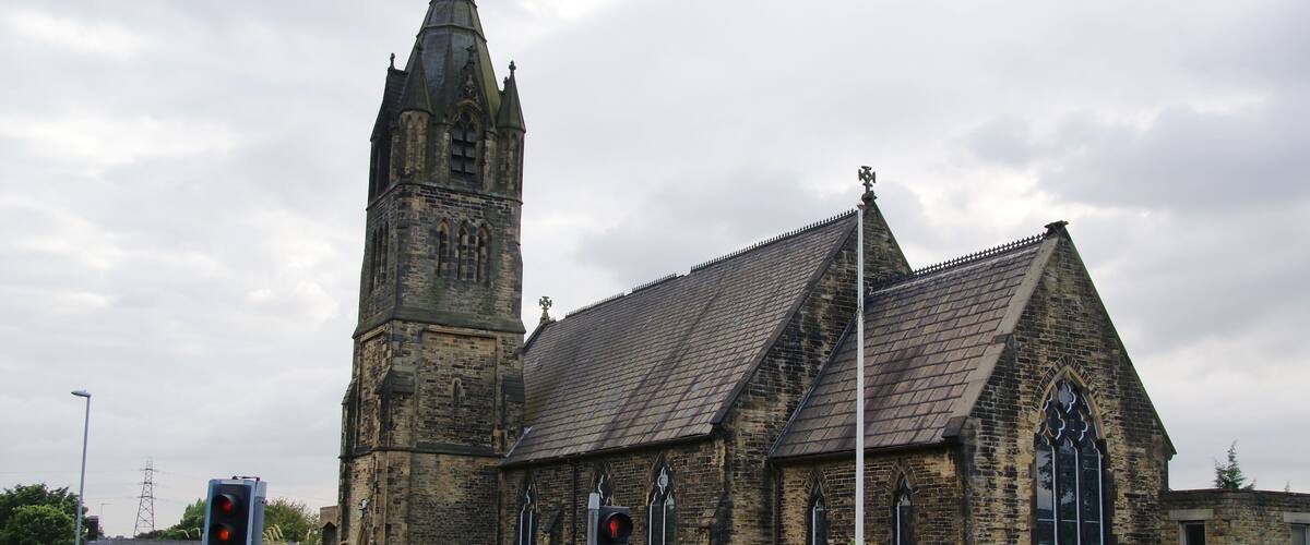 St. Matthew's Church with a tall tower and a signboard.