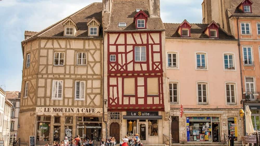Ein historisches Gebäude mit einem Café namens "Le Moulin à Café" und einem weiteren Lokal namens "La Suite".