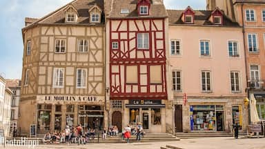 Un edificio histórico con una cafetería llamada “Le Moulin à Café” y otro establecimiento llamado “La Suite.”