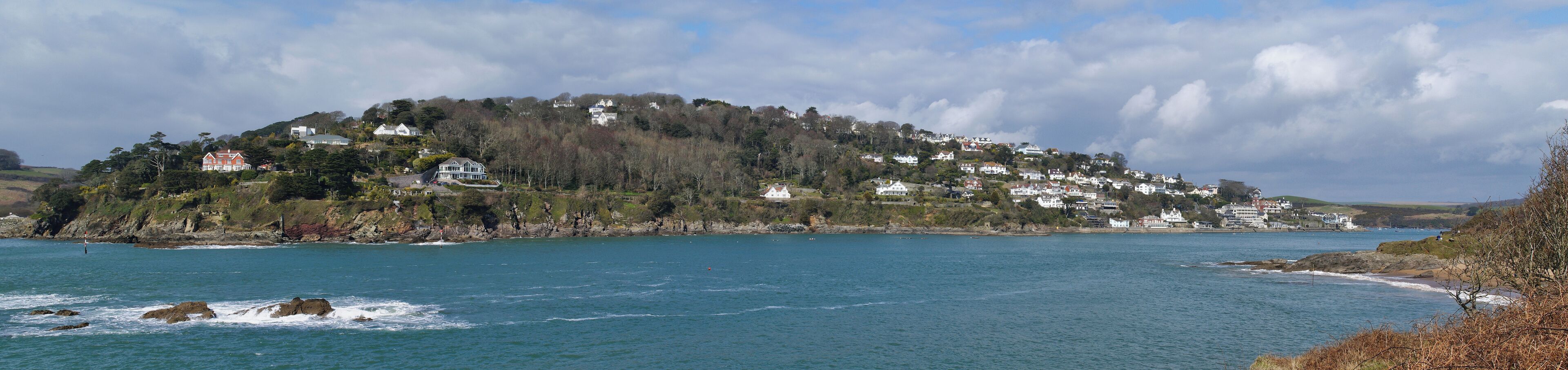 A coastal town with houses on a hillside overlooking the sea.