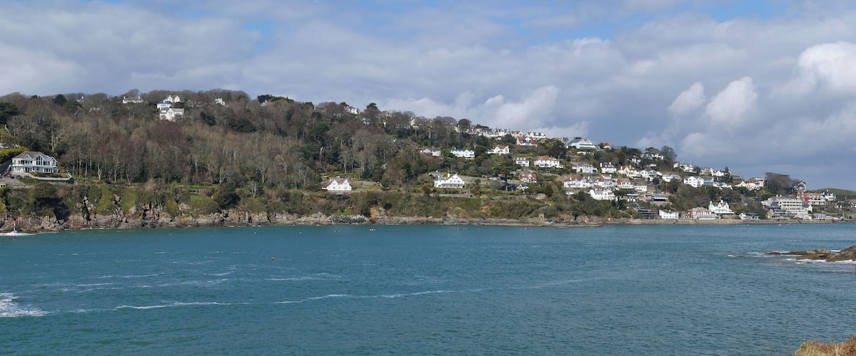 A coastal town with houses on a hillside overlooking the sea.